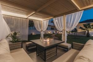 an outdoor patio with a table and chairs at Agrilia Hotel Adults Only in Laganas +84 photos