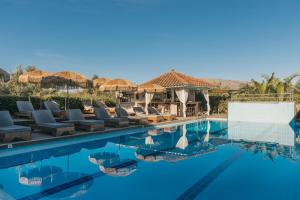 a pool at a resort with chairs and umbrellas at Agrilia Hotel Adults Only in Laganas