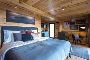 a bedroom with a large bed in a wooden cabin at Szarvashegy Panoráma Apartman in Szentendre