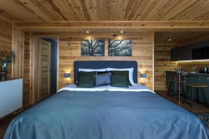 a bedroom with a large bed in a wooden room at Szarvashegy Panoráma Apartman in Szentendre