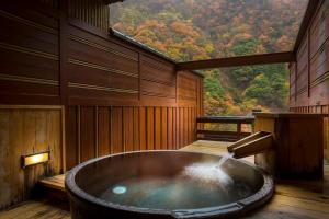 a bath tub in a room with a view at Enraku in Kurobe