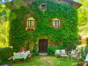 a house covered in ivy with a table in front of it at Casa rural Garata in Arantza