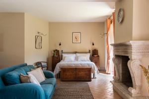 a bedroom with a bed and a couch and a fireplace at Podere Sant'Alessandro in Rapolano Terme +118 photos