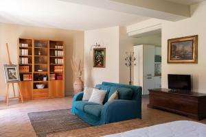 a living room with a blue couch and a tv at Podere Sant'Alessandro in Rapolano Terme