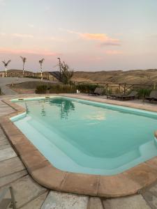 a swimming pool with blue water in a resort at Arabian Desert Home in Aït Mazou