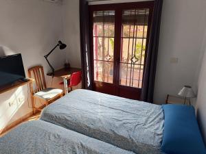 a bedroom with a bed and a desk and a window at Casa Cármenes del Mar in Almuñécar