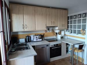 a kitchen with wooden cabinets and a sink at Casa Cármenes del Mar in Almuñécar