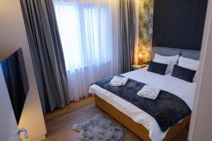 a bedroom with a bed with two towels on it at Nivalis Resort and SPA in Muntele Băişorii +45 photos