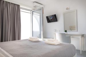 a bedroom with a bed with two towels on it at Beach Break Rhodes in Faliraki