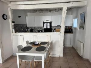 a kitchen with a table and chairs in a room at Le Marais Vous - Duplex en centre-ville. in Provins