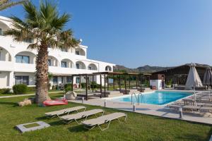 a resort with a swimming pool and a palm tree at Beach Break Rhodes in Faliraki
