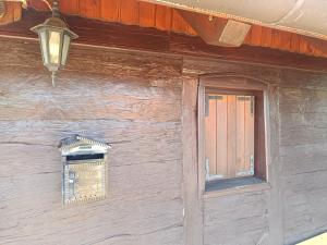 ein Holzgebäude mit einem Fenster und einer Lampe in der Unterkunft Sweet Dalia in Molvice + 12 Fotos