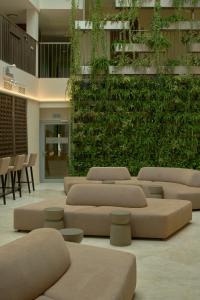 a lobby with a green wall with couches and chairs at Mana Suites & Sea SPA in Palanga