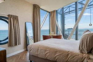 a bedroom with a bed and a view of the ocean at Punt al Mare in Vlissingen +13 photos