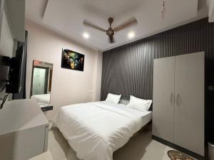 a bedroom with a white bed and a black wall at Hotel Pravas Inn in Lucknow