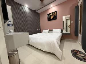 a bedroom with a large white bed in a room at Hotel Pravas Inn in Lucknow +4 photos