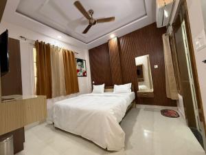 a bedroom with a large bed with a ceiling fan at Hotel Pravas Inn in Lucknow
