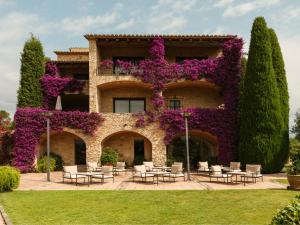 a large building with purple flowers on it at Mas de Torrent Hotel & Spa, Relais & Châteaux in Torrent