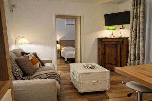 a living room with a couch and a bedroom at Lodge avec piscine chauffée privative et ou Studio avec son SPA, SAUNA HAMAMM privatifs in Cepoy