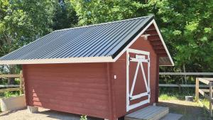 a red dog house with a gray roof at Pikku aitta in Heikkilä