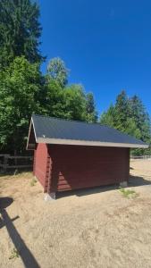 a large red barn with a black roof at Pikku aitta in Heikkilä