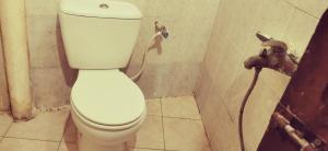 a white toilet in a bathroom with a faucet at lala salama in Zanzibar City