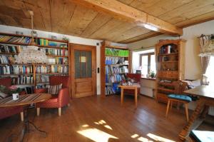 a living room with bookshelves and a table and chairs at Landhotel Binderhäusl Garni in Inzell