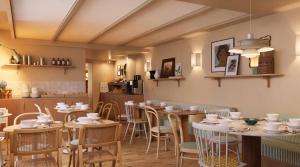 ein Restaurant mit Tischen und Stühlen und einer Küche in der Unterkunft Alfred Hotels Paris Lecourbe- Hôtel Rénové in Paris