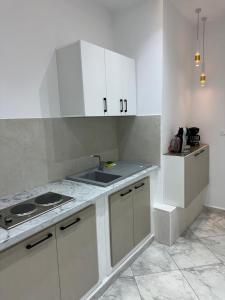 a kitchen with white cabinets and a sink at Cozy Corner in Sousse +10 photos