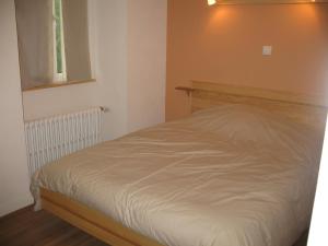 a white bed in a room with a window at Hôtel Bar Restaurant de la Poste Le 1900 in Jougne