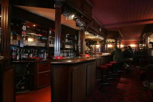 a bar with a row of stools in a restaurant at Hôtel Bar Restaurant de la Poste Le 1900 in Jougne