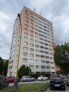 a large building with cars parked in a parking lot at Apartmán Košice Nad Jazerom in Košice