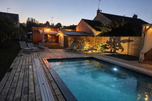 a swimming pool in the backyard of a house at Lodge avec piscine chauffée privative et ou Studio avec son SPA, SAUNA HAMAMM privatifs in Cepoy