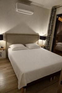 a bed with white sheets and pillows in a room at Lodge avec piscine chauffée privative et ou Studio avec son SPA, SAUNA HAMAMM privatifs in Cepoy +32 photos