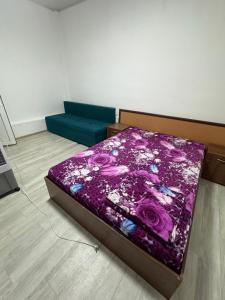 a bed in a room with a purple blanket at Зона отдыха Мирас in Kapchagay