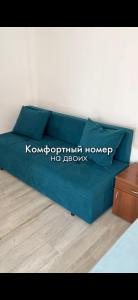 a blue couch sitting in a living room at Зона отдыха Мирас in Kapchagay