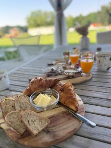 a wooden table with bread and butter on a cutting board at Farma P&P Apartmány in Vrchovany