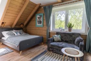 a bedroom with a bed and a chair at Przytulisko Bieszczady in Smerek