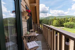 a balcony with a table and a view of the mountains at Przytulisko Bieszczady in Smerek