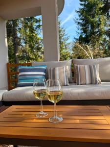 two glasses of white wine sitting on a wooden table at Hidden pines in Gornji Čevljanovići