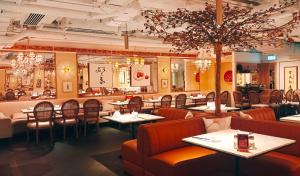 a restaurant with tables and chairs in a room at Charterhouse Causeway Bay in Hong Kong