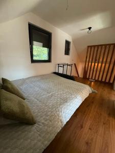 a bedroom with a large bed with a window at Hidden pines in Gornji Čevljanovići