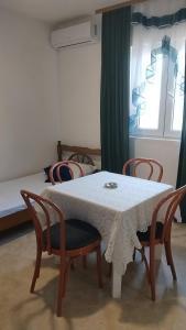 a room with a table and chairs and a bed at Nada Rooms in Budva