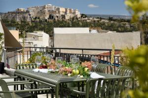 a table with flowers and wine glasses on a balcony at AIONION RESIDENCES by K&K in Athens