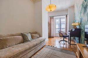 a living room with a couch and a desk at A cozy hideout in Lisbon