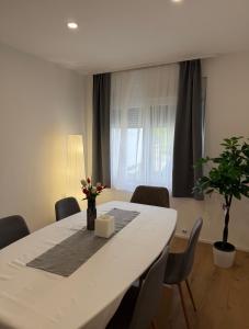 a dining room table with chairs and a vase with flowers at Studio apartman Katja in Karlovac