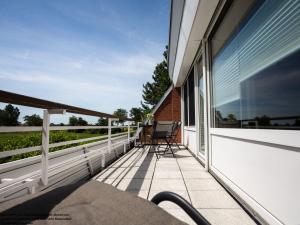a balcony of a house with a chair on it at FeWo Friesenperle - Schillig in Horumersiel
