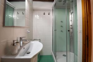 a bathroom with a sink and a glass shower at Sotto la torre Apartment in Cagliari