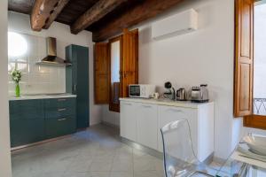 a kitchen with a white counter and a microwave at Sotto la torre Apartment in Cagliari +4 photos