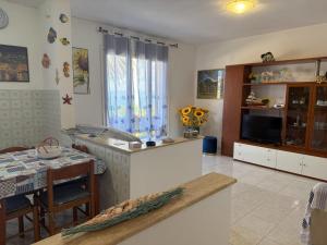 a kitchen and dining room with a table and a television at Fiore's house in Porto Santo Stefano